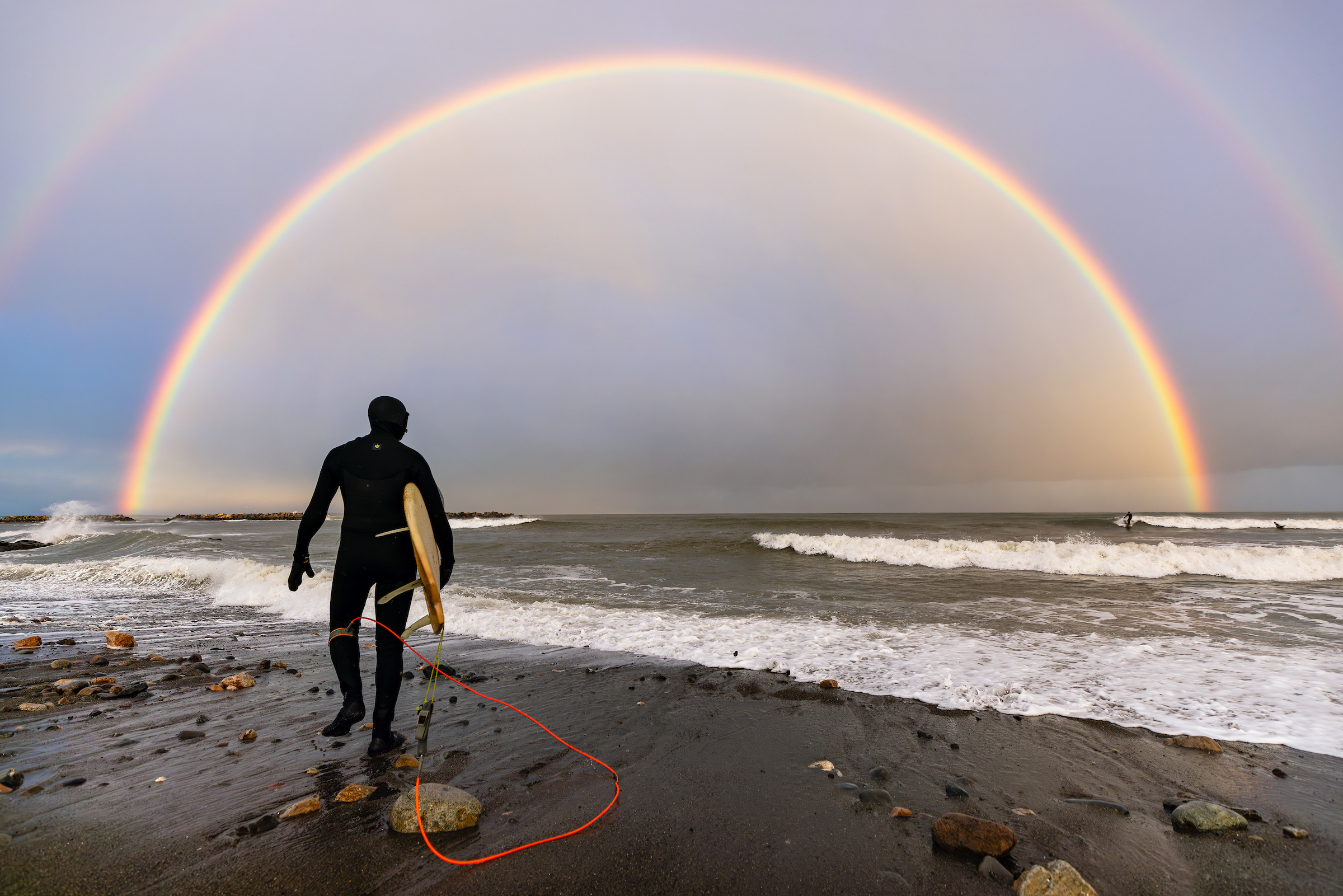 Jan. 13, 2024: Surfers catch a wave and a rainbow during a unique winter weather moment on Winthrop Beach.