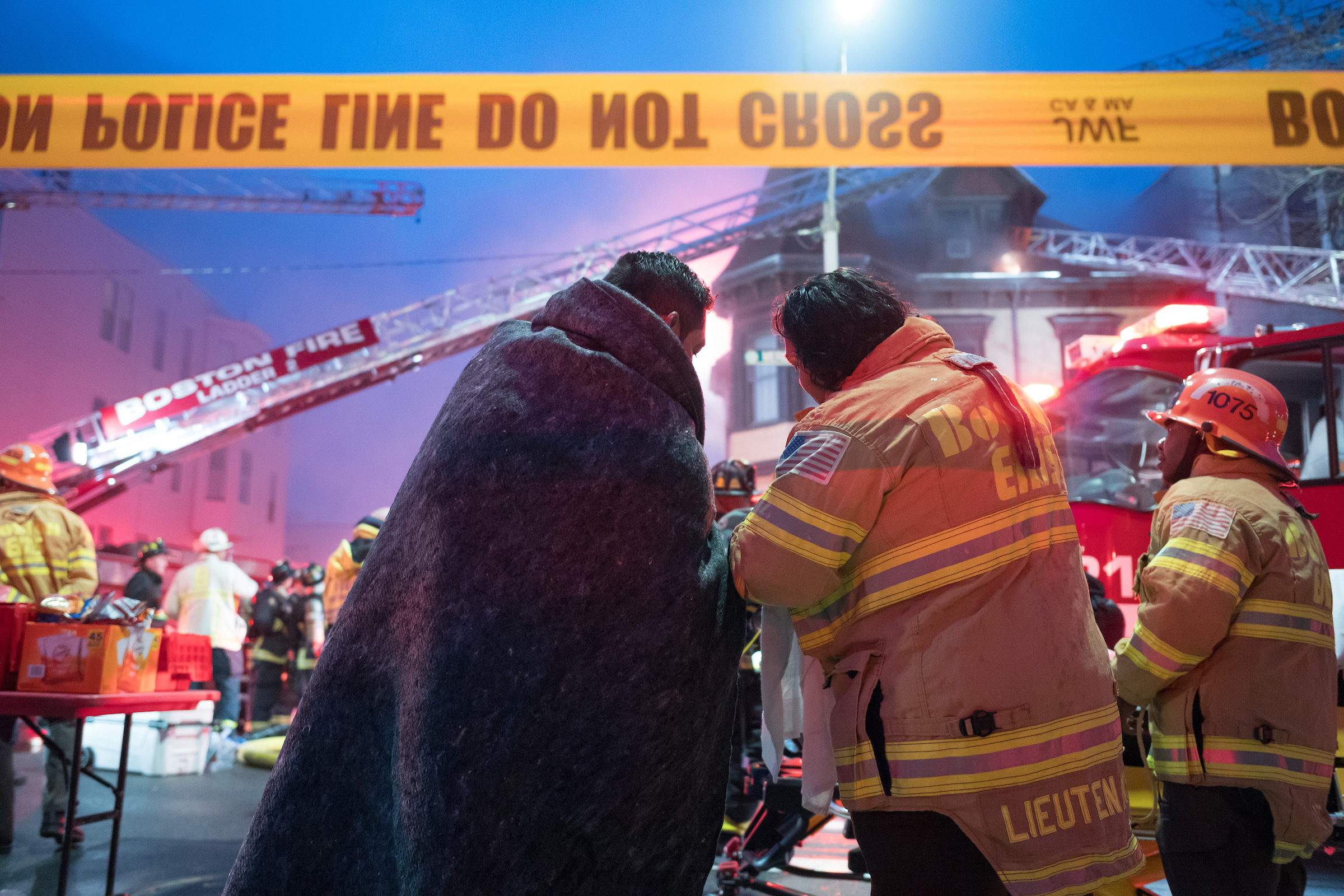 Boston firefighters and Boston EMS render aid at the scene of a large fire on East Boston’s Meridian Street. A 10-year-old girl and an adult perished in the early morning blaze.