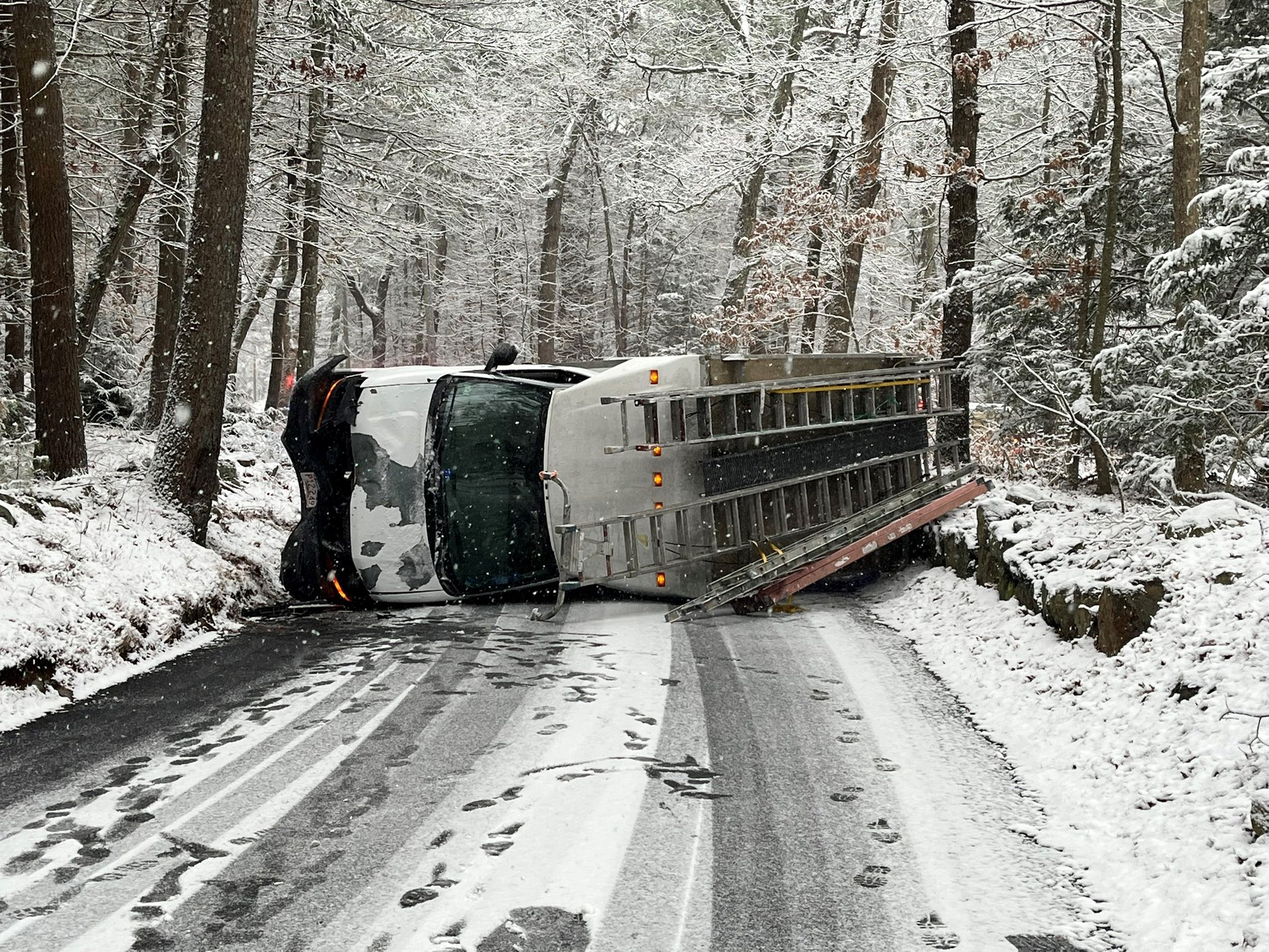 A toppled-over van on a snowy street in Wellesley, Massachusetts, on Friday, Dec. 20, 2024.