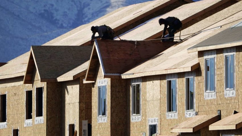 Workers install roofing on an apartment complex under construction in Lehi, Utah, on Friday, Jan. 7, 2022.