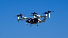 An "electric vertical take-off and landing" aircraft built by Joby Aviation flies over an airfield in Marina, Calif. on Monday, Oct. 7, 2024. (AP Photo/Terry Chea)