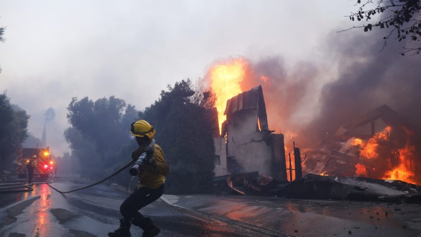 A firefighter battles the advancing Palisades Fire